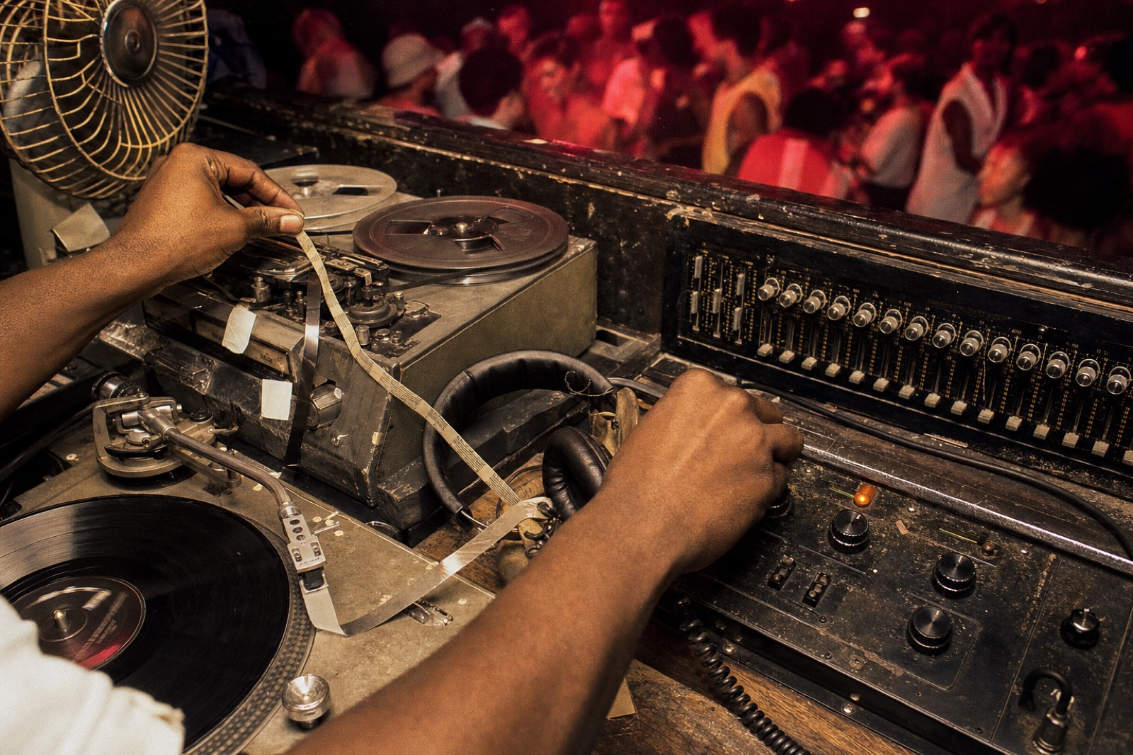 Chicago house DJ booth with reel tape mixer records and raw Music Box club lighting